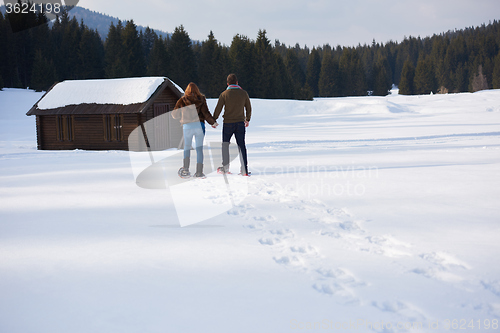 Image of couple having fun and walking in snow shoes