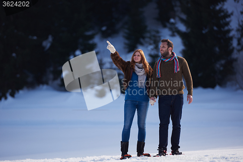 Image of couple having fun and walking in snow shoes