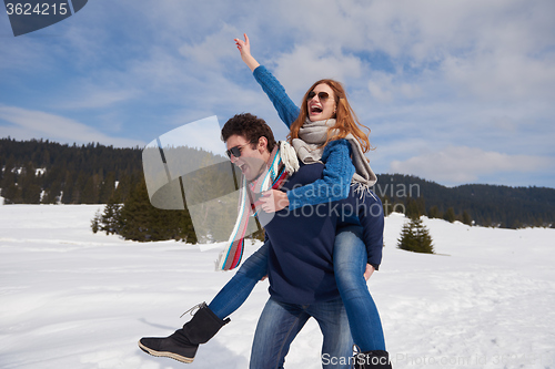 Image of happy young couple having fun on fresh show on winter vacation