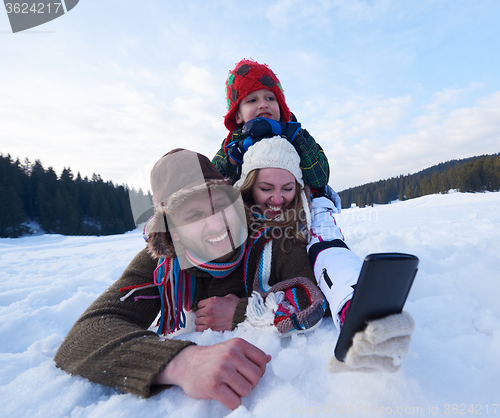Image of romantic couple have fun in fresh snow and taking selfie