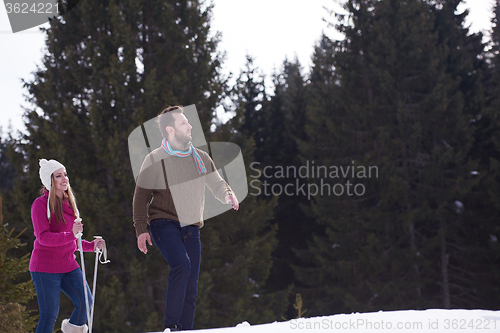 Image of couple having fun and walking in snow shoes
