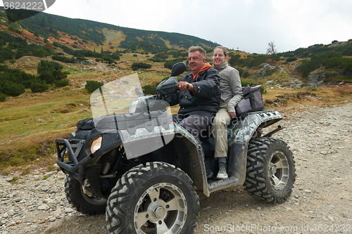 Image of couple drive atv quad bike