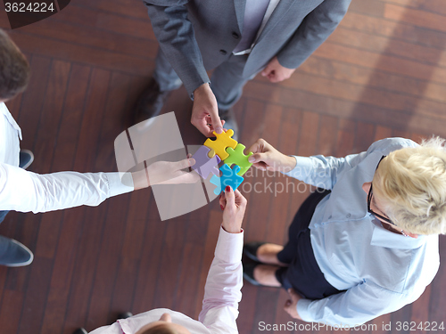 Image of business people group assembling jigsaw puzzle