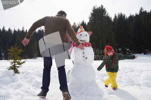 Image of happy family building snowman