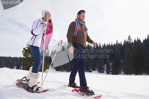 Image of couple having fun and walking in snow shoes