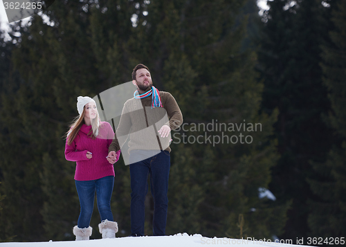 Image of couple having fun and walking in snow shoes