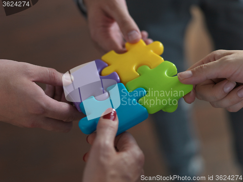 Image of business people group assembling jigsaw puzzle