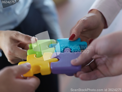 Image of business people group assembling jigsaw puzzle