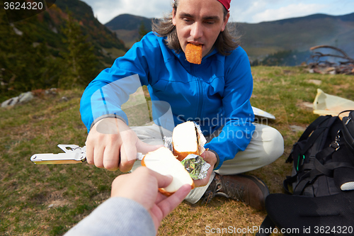 Image of hiking man slice tasty cheese on picnic