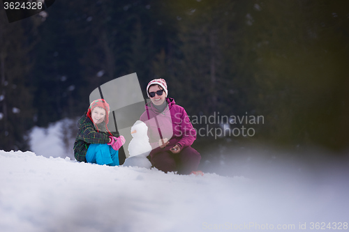 Image of happy family building snowman