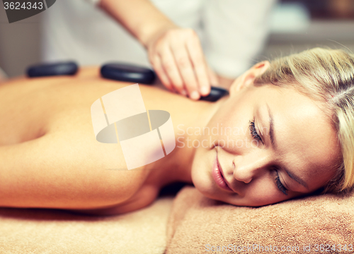 Image of close up of woman having hot stone massage in spa