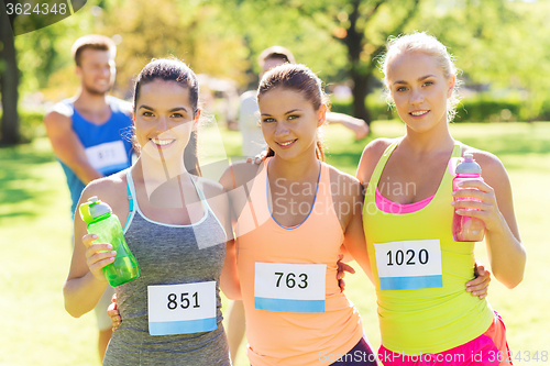 Image of women with racing badge numbers and water bottles