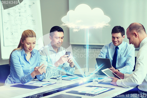 Image of smiling business people with gadgets in office