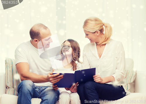 Image of happy family with book at home