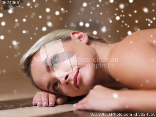 Image of young woman lying on hammam table in turkish bath