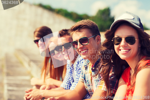 Image of close up of smiling friends sitting on city street