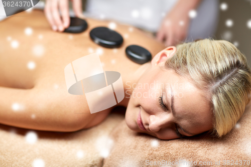 Image of close up of woman having hot stone massage in spa