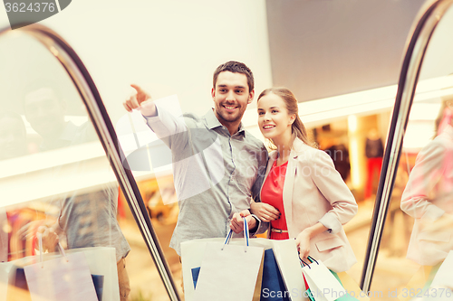 Image of happy young couple with shopping bags in mall