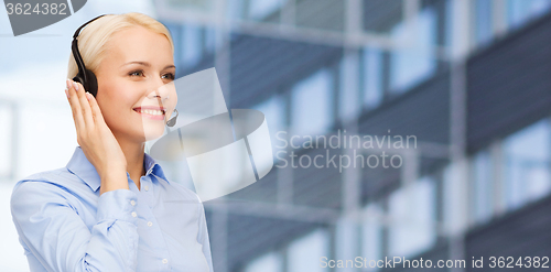 Image of helpline operator in headset over business center