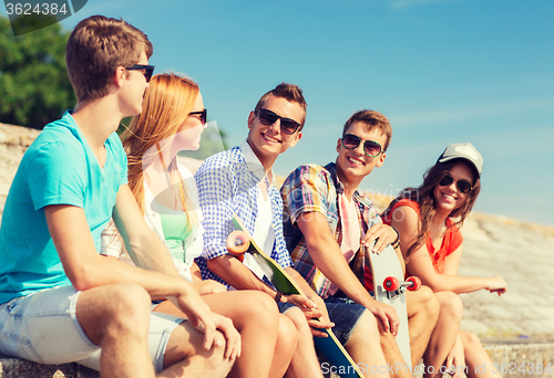 Image of group of smiling friends sitting on city street