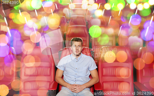 Image of happy young man watching movie in theater