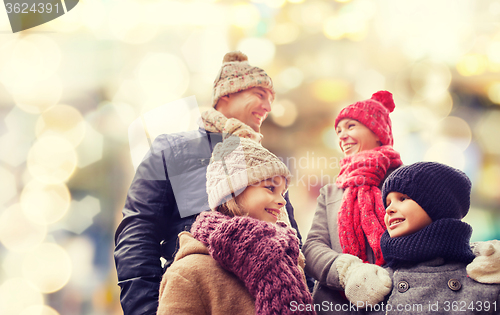 Image of happy family in winter clothes outdoors