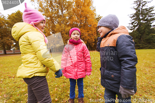 Image of group of happy children talking in autumn park