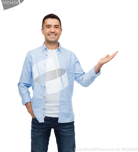Image of smiling man showing something on empty palm