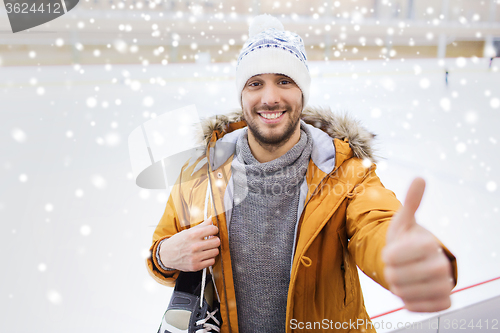 Image of happy young man showing thumbs up on skating rink