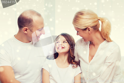 Image of smiling parents and little girl at home