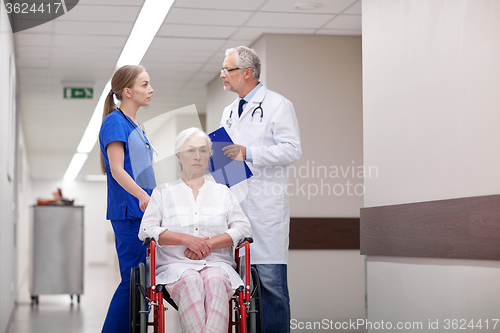 Image of medics and senior woman in wheelchair at hospital