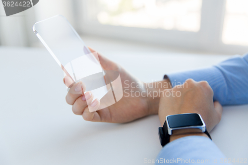 Image of close up of hands with smart phone and watch