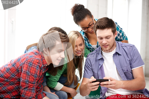 Image of group of happy students with smartphone at school