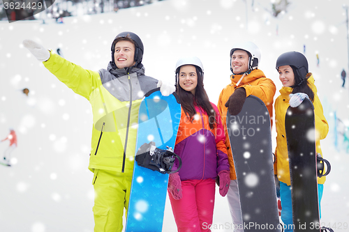 Image of happy friends in helmets with snowboards