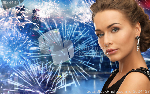 Image of beautiful woman wearing earrings over firework