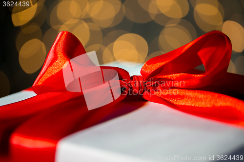 Image of close up of christmas gift with bow over lights