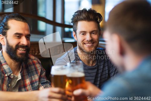 Image of happy male friends drinking beer at bar or pub