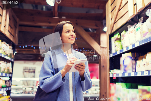 Image of happy woman with notepad in market