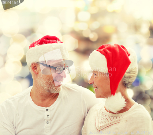 Image of happy senior couple in santa helper hats