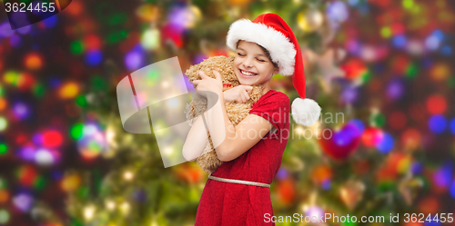 Image of smiling girl in santa helper hat with teddy bear