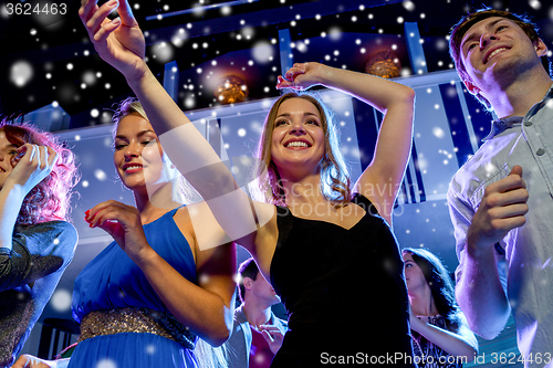 Image of smiling friends dancing in club