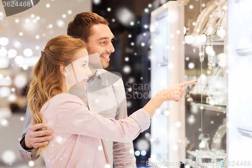 Image of couple looking to shopping window at jewelry store