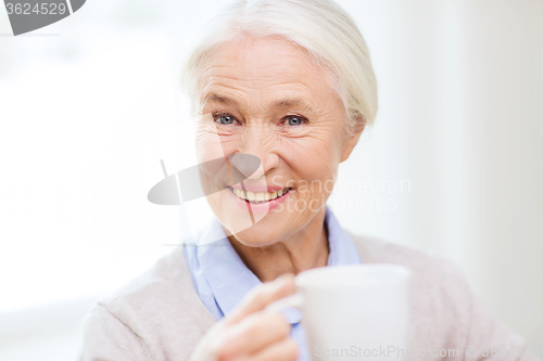 Image of happy senior woman with cup of tea or coffee