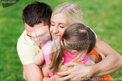 Image of happy family hugging outdoors