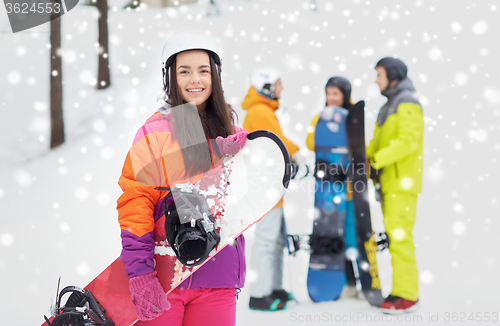 Image of happy friends in helmets with snowboards