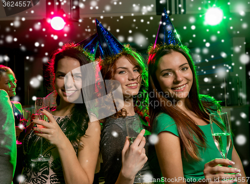 Image of smiling friends with glasses of champagne in club