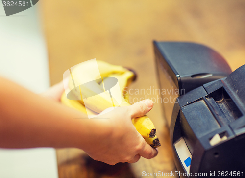 Image of close up of hands buying bananas at checkout