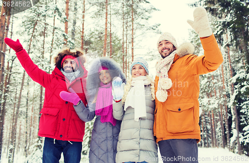 Image of group of friends waving hands in winter forest