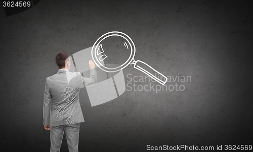 Image of businessman drawing magnifier