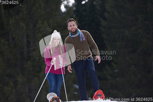 Image of couple having fun and walking in snow shoes